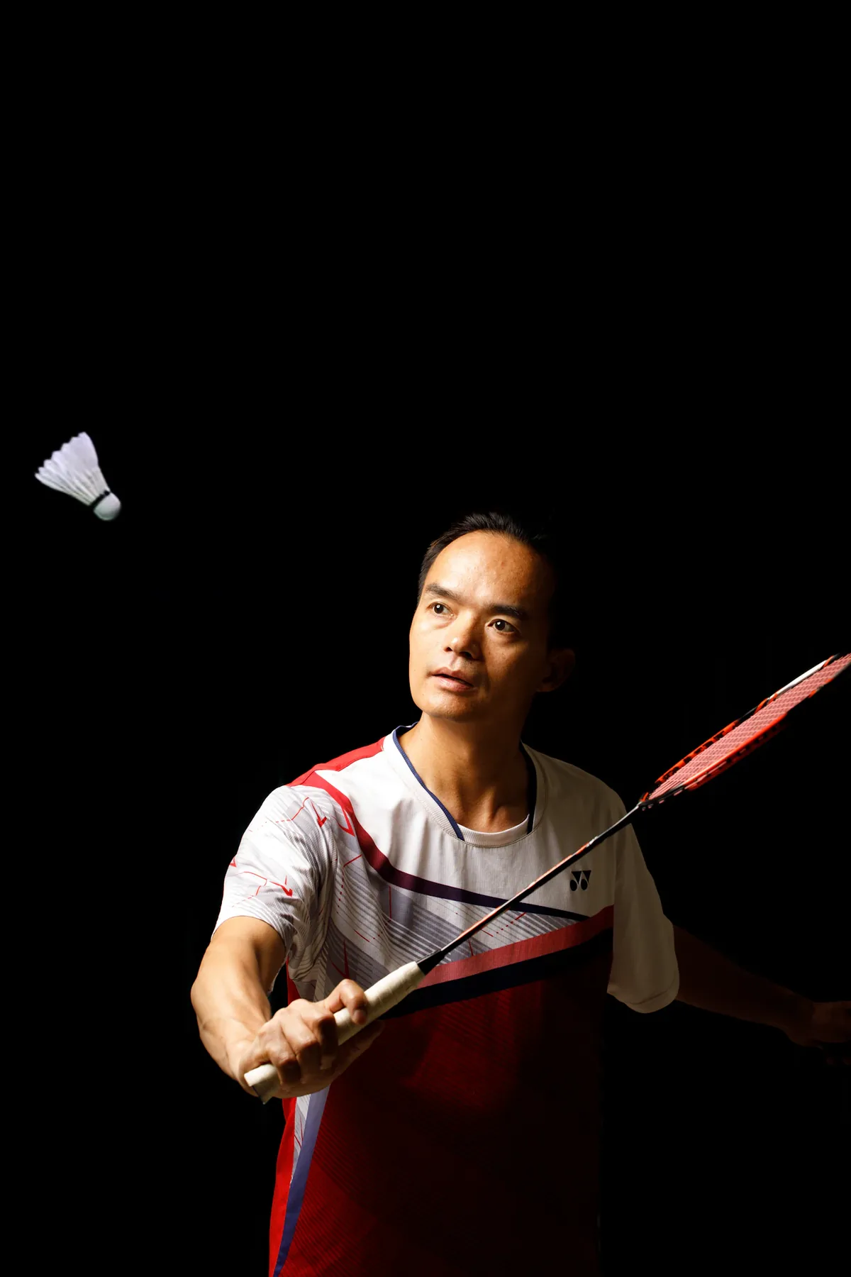 A badminton player preparing to return the shuttlecock