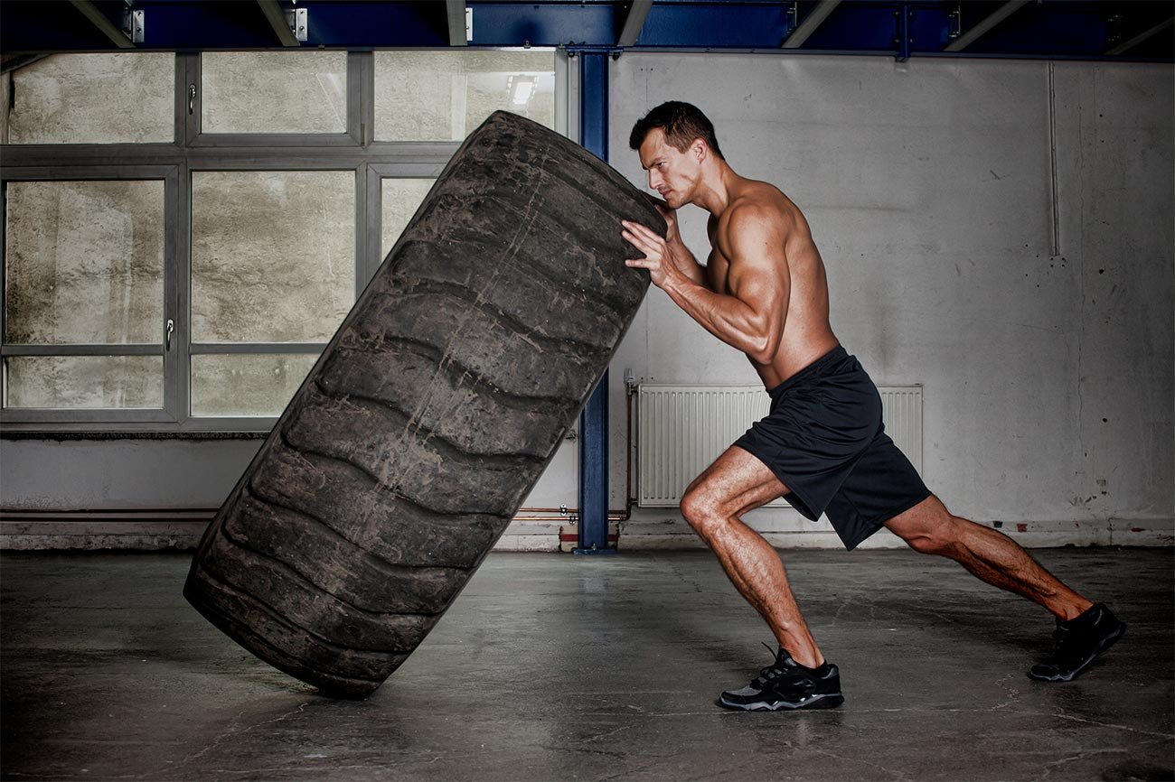 Men pushing a tire